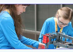 Girls building robot in STEM classroom