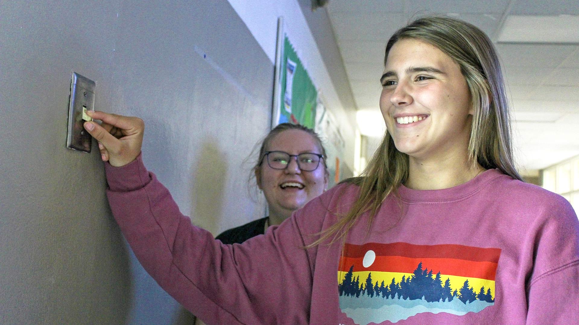 School Uplift energy team student flips light switch