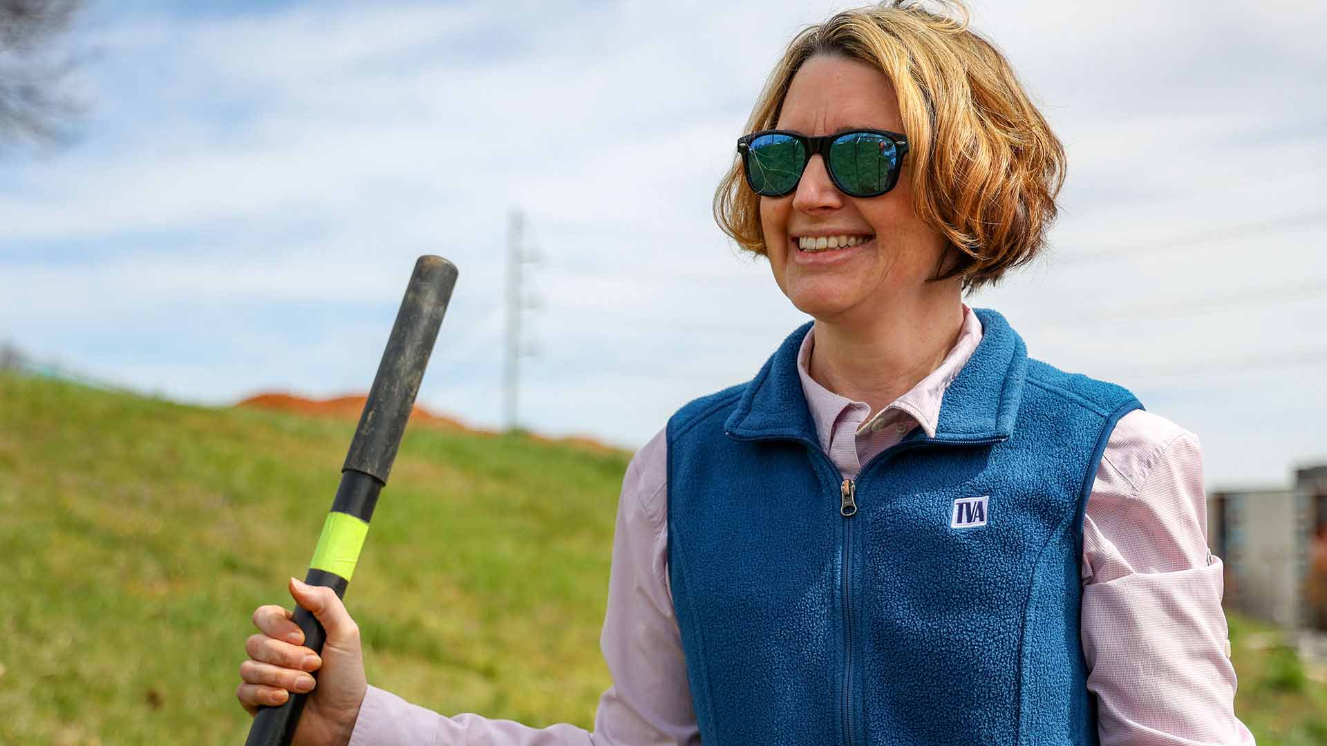 Woman in TVA vest holding shovel