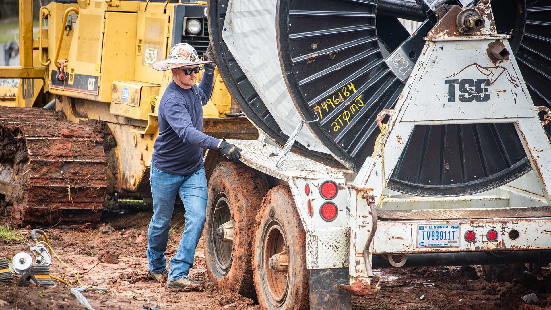 Lineworker Clay Johnson with giant reel of wire