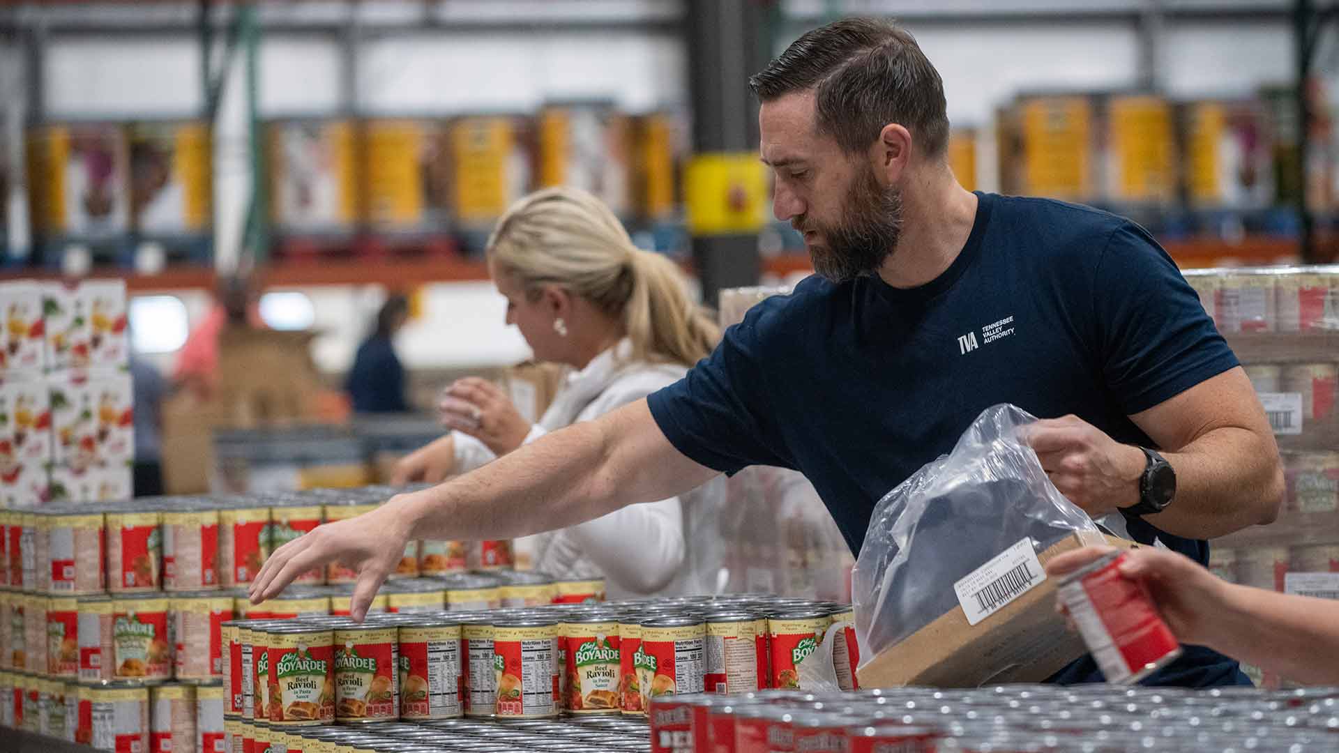 TVA employee packing canned goods at food pantry distribution