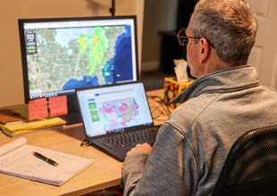TVA Meteorologist studying weather pattern on computer screens