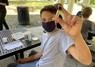 Kid holding water testing vial