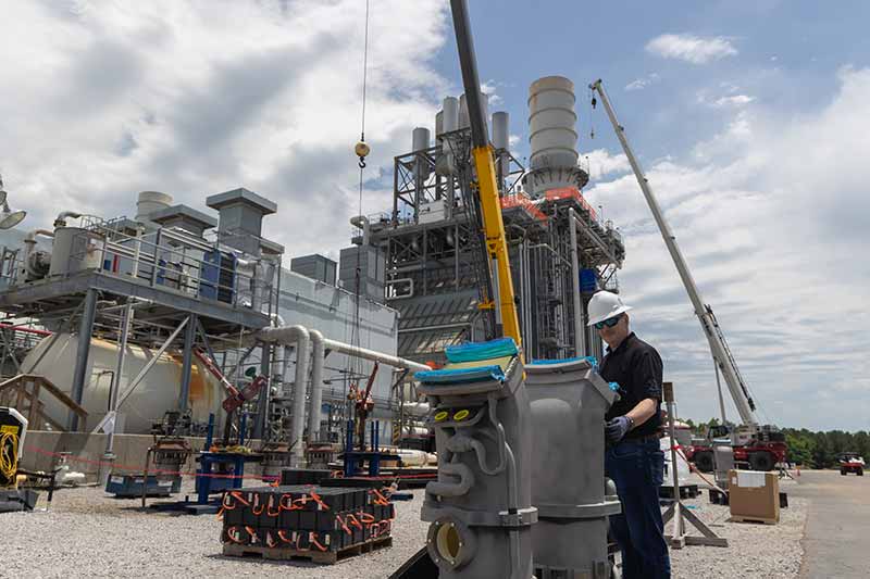 Ackerman Combine Cycle Plant Manager Keith McMillion surveys gas turbine parts