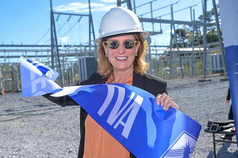 Woman holding portion of ribbon that says TVA