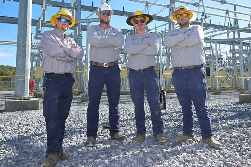 BTES event - group wearing hard hats standing in front of substation
