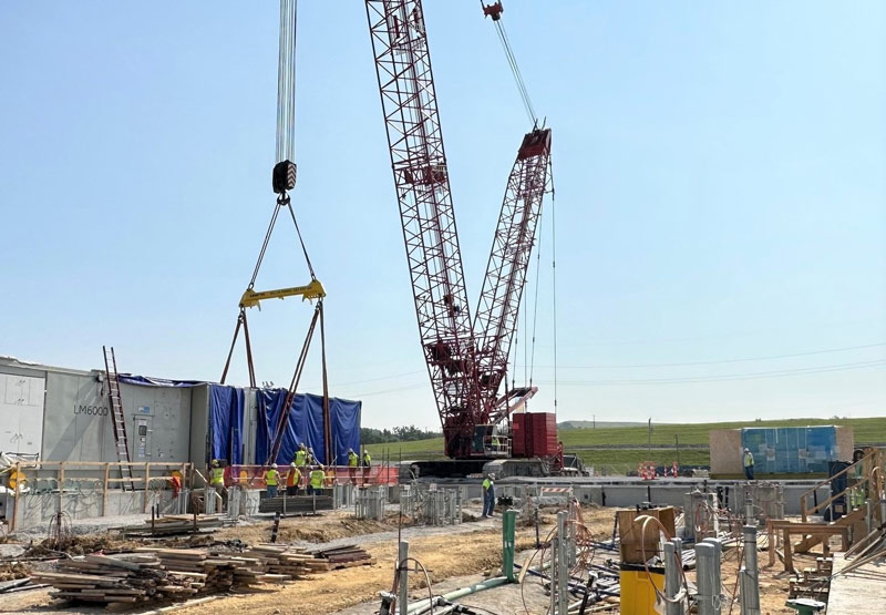 A large crane is used to maneuver aeroderivative gas turbine components at an overseas location