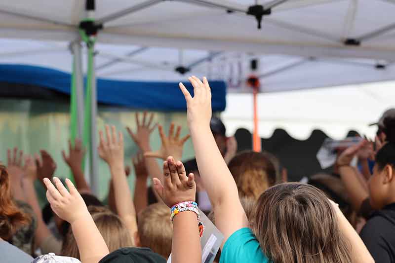 Kids raise hands in the air.