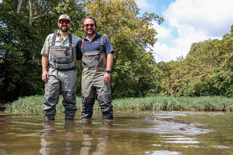 People standing in stream with waders on.