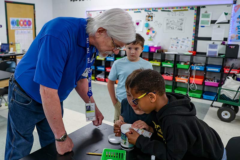 Volunteer Stuart Neil helps students test water.