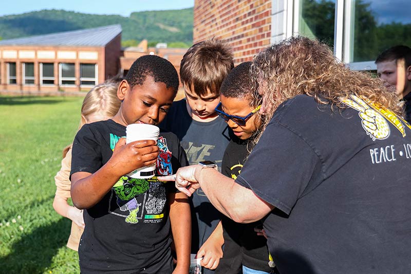 Teacher Mandy Carter helps students read water temperature.