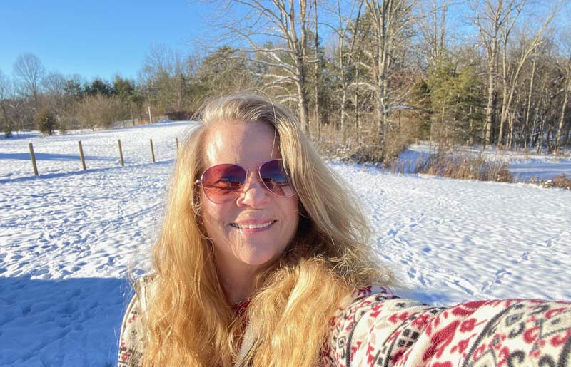 Bonnie Bruce taking a selfie with a snowy landscape in the background