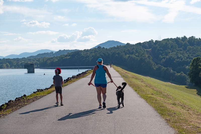 An adult and two children walk along a Chatuge Reservoir trail