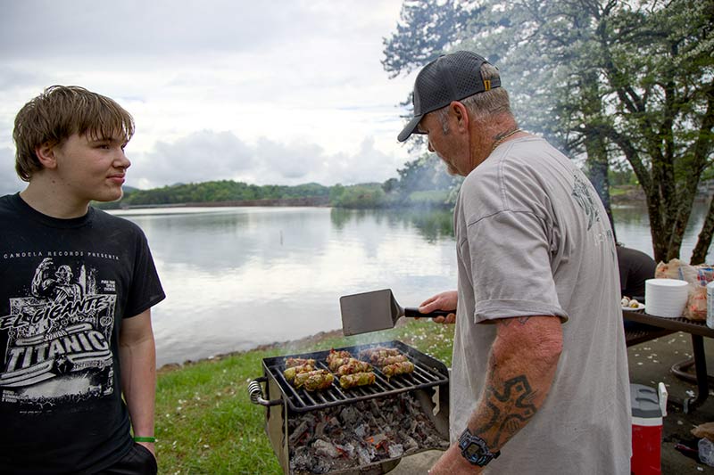 Mike Tanner and son cooking on grill.