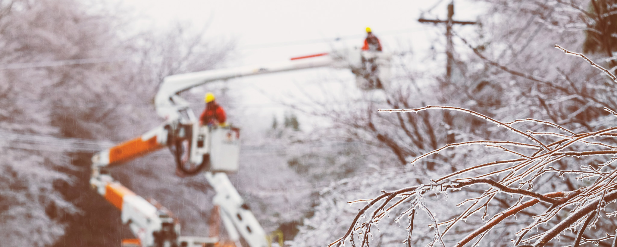 Linemen working to restore power during an intense ice storm Linesmen working to restore power during an intense ice storm