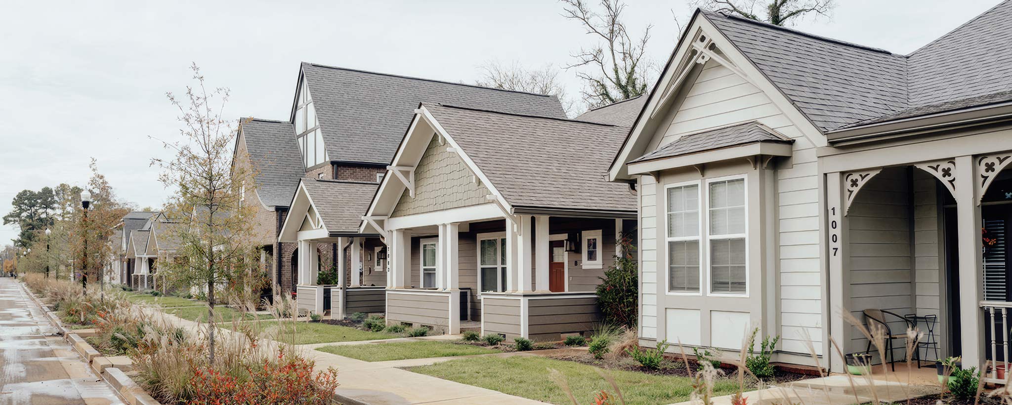 Row of single-story homes Row of modern, single-story homes with front porches and landscaped walkways