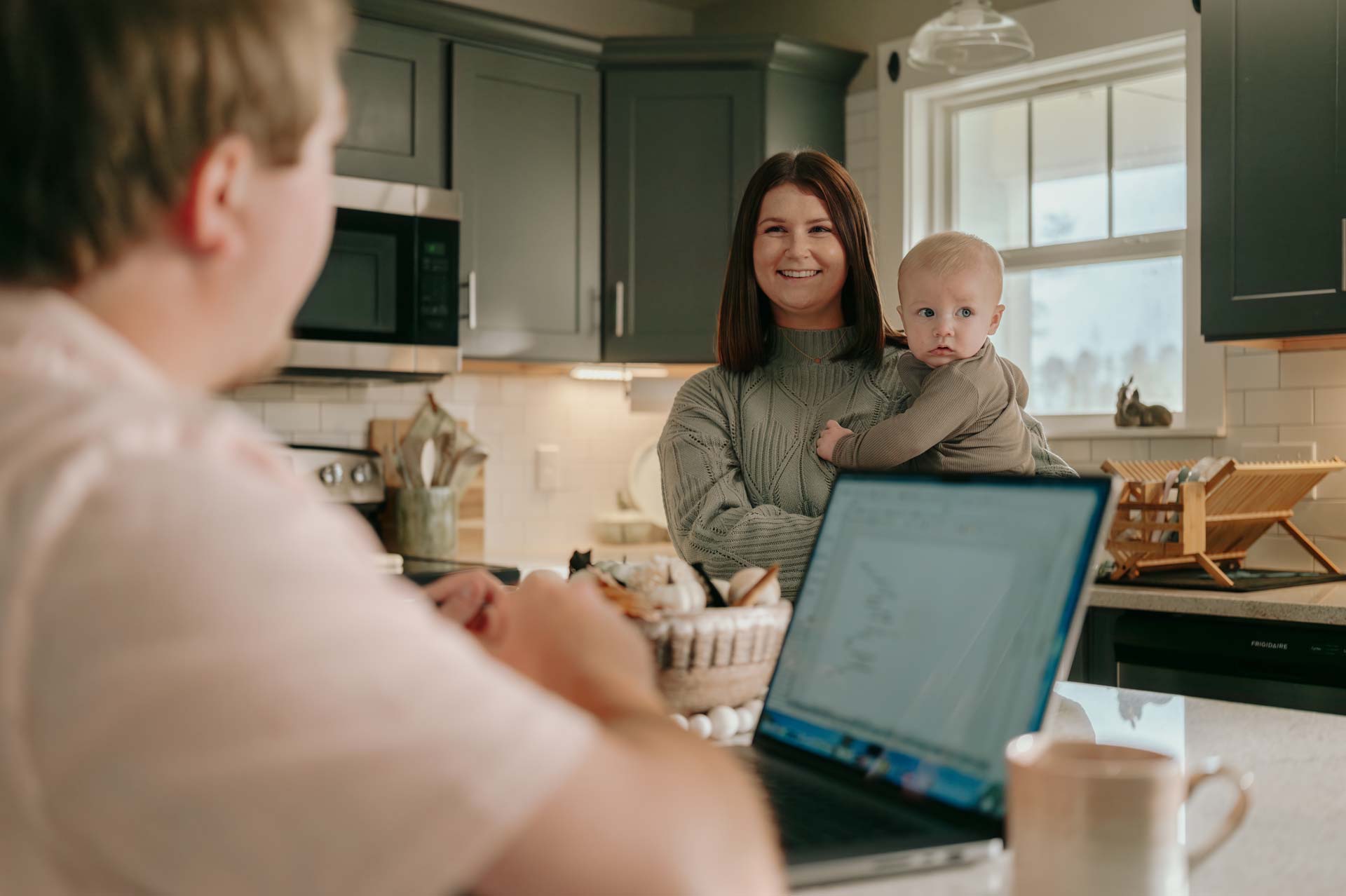Woman holding a baby and smiling.