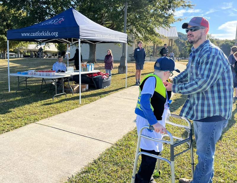 Participant Paxton Gladden has help from his dad as he puts on his life jacket.  