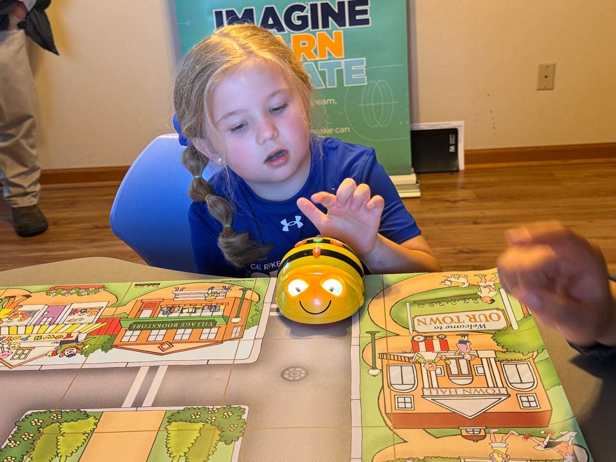 Child using a small robot toy on a play mat