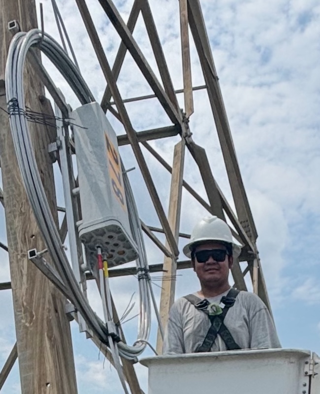 Man next to transmission tower