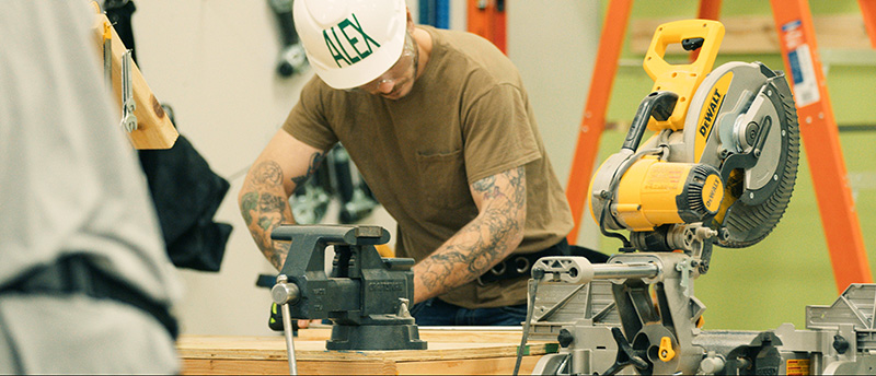 Man learning to use woodworking tools