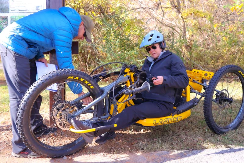 Catalyst Sports founder Eric Gray makes an adjustment to a bike that Knox County ADA coordinator Carly Pearson rides at Trotter Bluff Trail