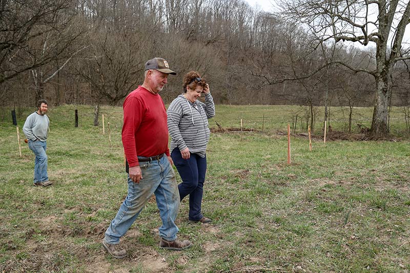 Farmers and TVA's Kathy Hawes walking through field