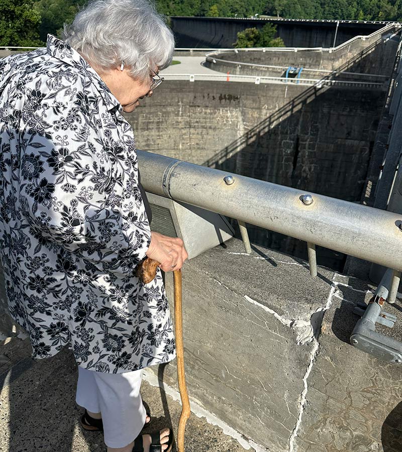 Judy Stearns looks at coin impressions in the concrete of Fontana Dam.
