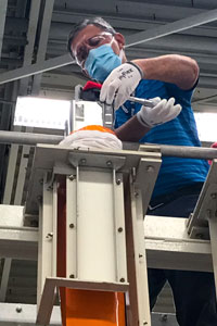 Employee loading the 3D-printed fuel assembly brackets 