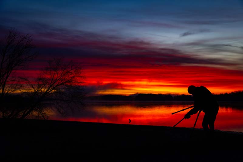 A birdwatcher adjusts a tripod during a sunrise visit to Hiwassee Wildlife Refuge in Birchwood, Tennessee