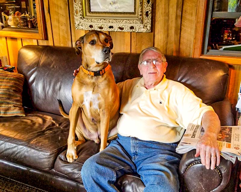 Huburt Turner sits with his dog at home