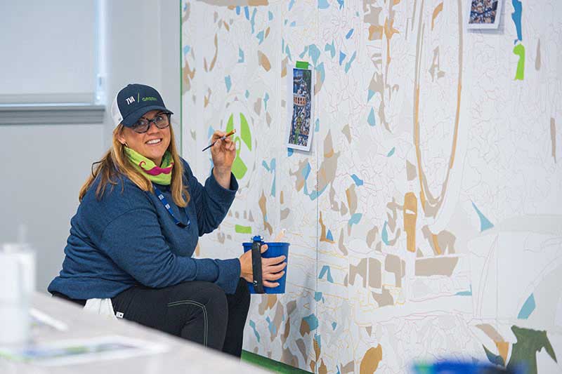 Karen Estes painting a portion of a wall at Raccoon Mountain.