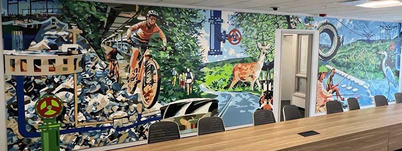 The completed mural is on a wall in a conference room.
