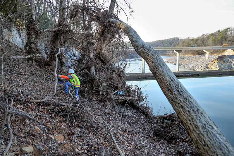 Matt Huebner scrambles through hurricane-damaged areas to reach cliffs at Nolichucky Dam.