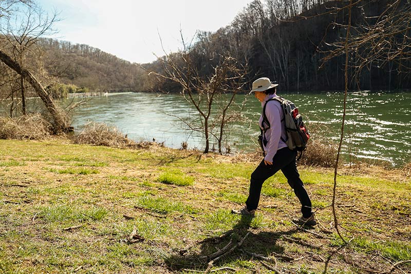 Visitor hiking along river shoreline