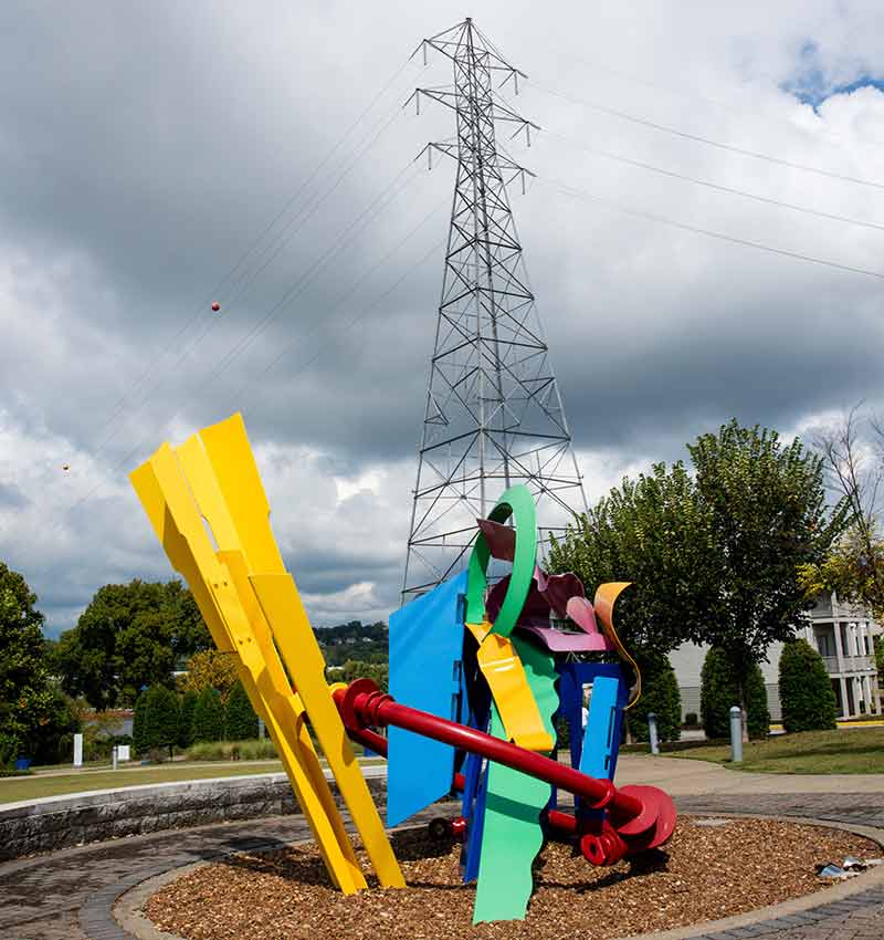 Brightly colored sculpture with transmission tower in background