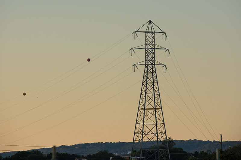 Transmission tower with lines stretching from it.