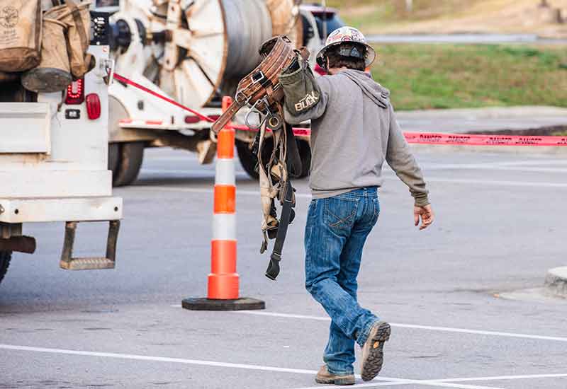 Lineworker carrying gear