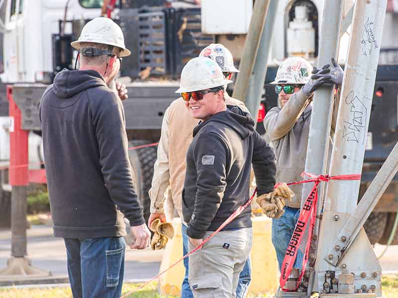 Lineworkers standing in group talking
