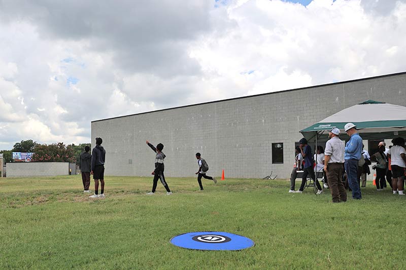 Students point skyward as the drone readies for landing.