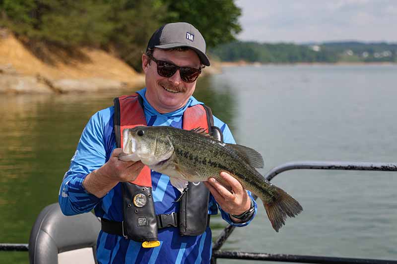 TVA fish biologist Kevin Parr shows one of the sport fish caught during the spring survey on Douglas Lake.