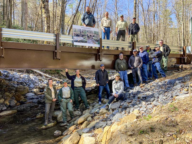 Team members from TVA and partnering organizations stand proudly at the Wolf Creek bridge