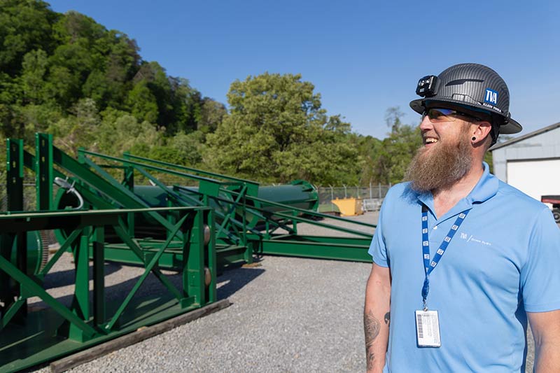 Ted Freeman smiling near crane at Ocoee