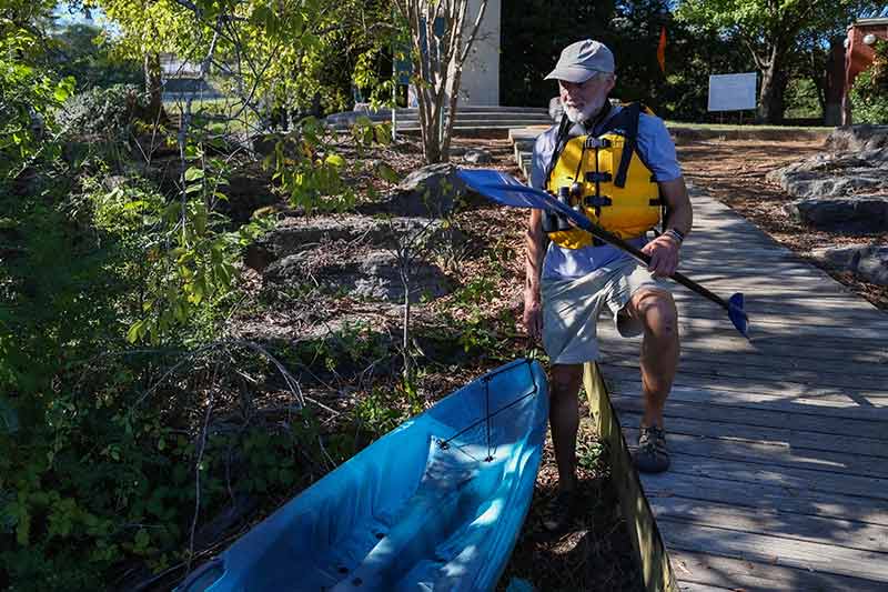 Volunteer with kayak on land