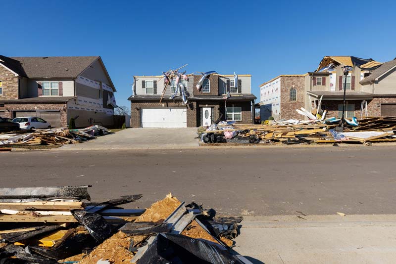 Piles of debris surround tornado-damaged homes