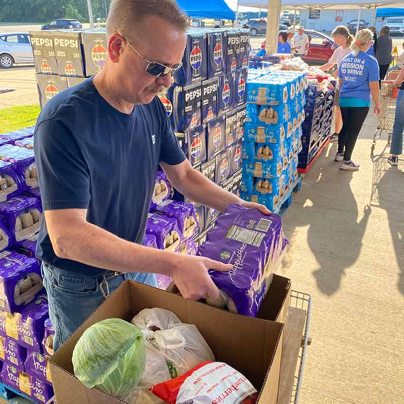 TVA employee prepares food for distribution at food pantry