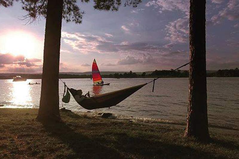 TVA Fun photo of person relaxing in hammock at lakeside sunset