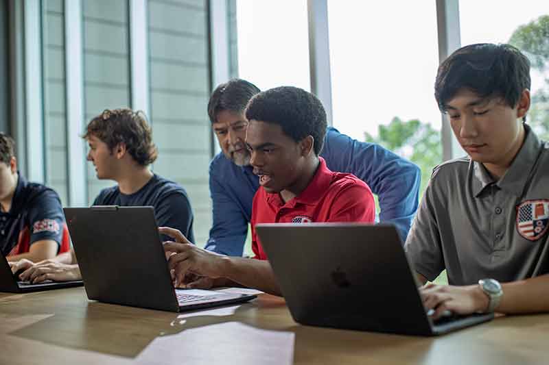 Alabama School of Cyber Technology and Engineering student and teacher discuss assignment