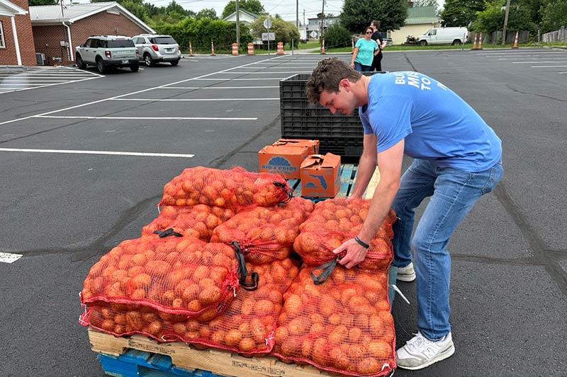 Week of Service 92nd anniversary volunteer loads potatoes