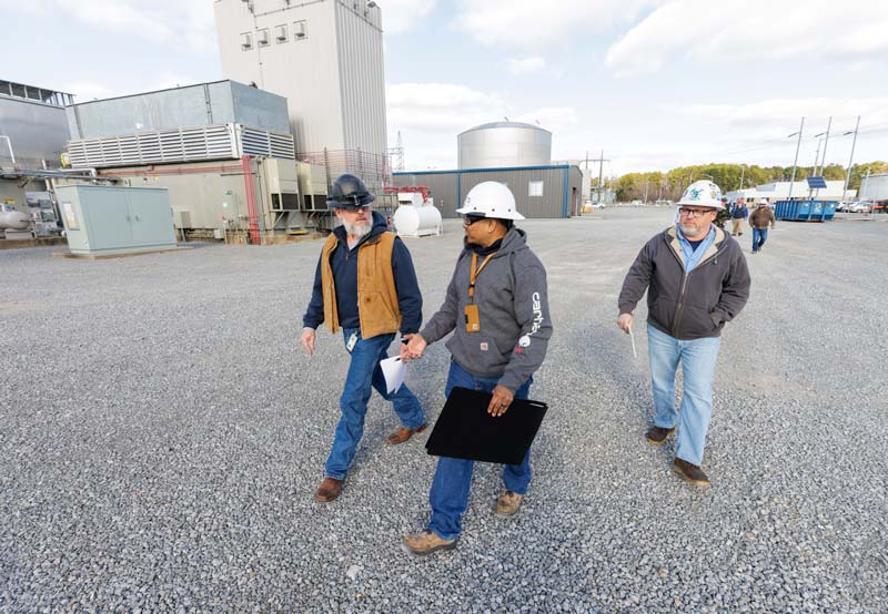 Workers walk across a gravel lot outside Gallatin Combustion Turbine Plant in Sumner County, Tennessee